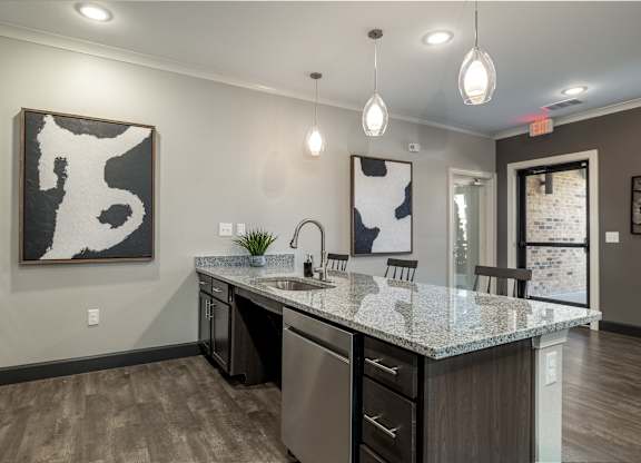 A modern kitchen with a large island and a painting hanging above it.