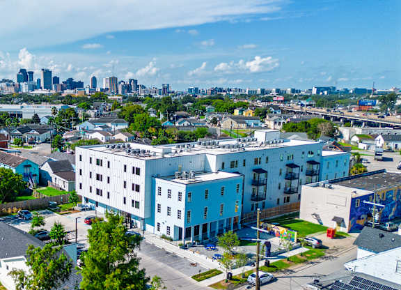 A cityscape with a mix of residential and commercial buildings under a clear sky.