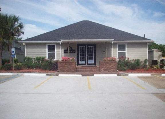 A small building with a parking lot in front.
