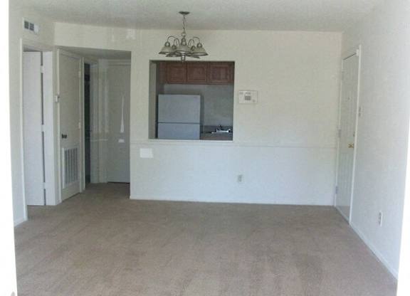 A room with a chandelier and a kitchenette.