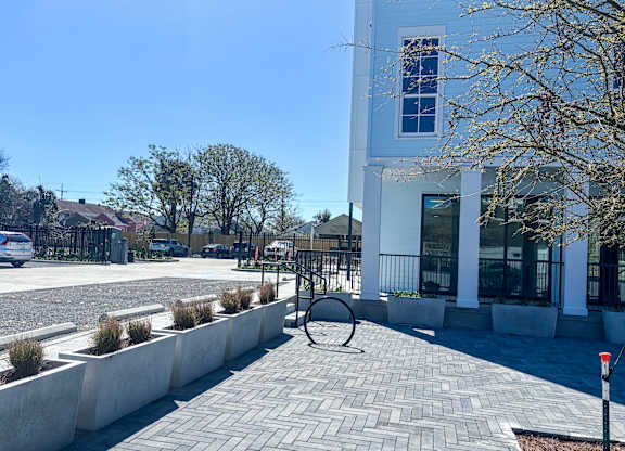 A white building with a black gate and a white fence.