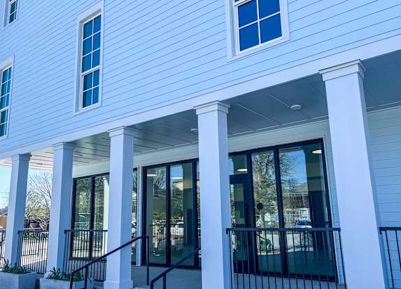 A white building with blue trim and a black railing.