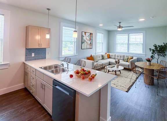 A modern kitchen with a white island and wooden floors.