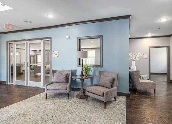 A waiting room with chairs and a table with a vase of flowers on it.