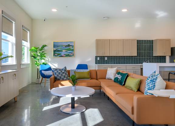 A living room with a couch, chairs, and a table.