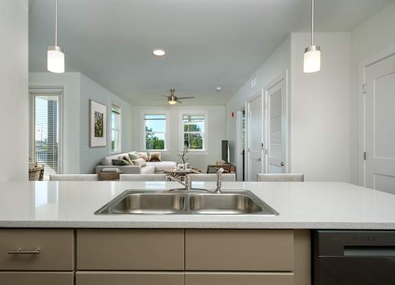 A modern kitchen with a large island and a stainless steel sink.