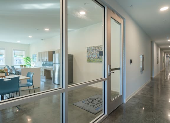 A hallway with a glass door leading to a dining area.