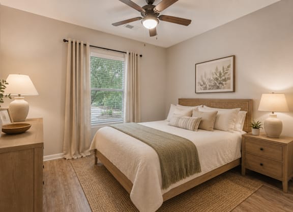 A bedroom with a bed, nightstands, and a ceiling fan.