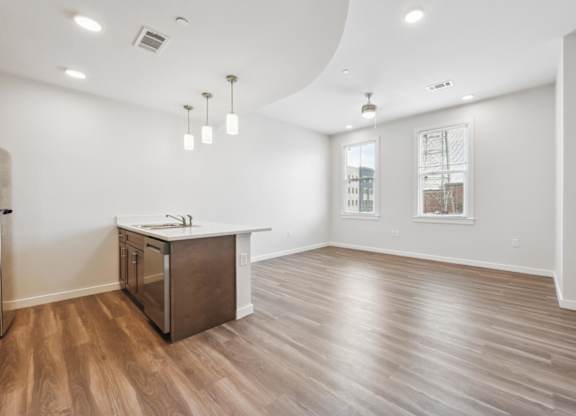 A kitchen with wooden floors and a white counter.