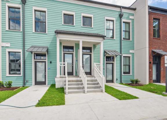 A blue house with a white door and windows.