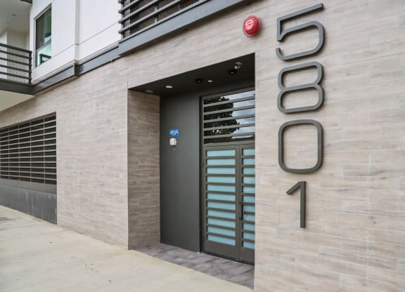 a view of the entrance to the building with the number 5690 on the side at The Fairfax Flats Apartments, Los Angeles, CA