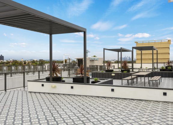 a roof deck with seating and a pergola at The Fairfax Flats Apartments, Los Angeles, CA, 90019