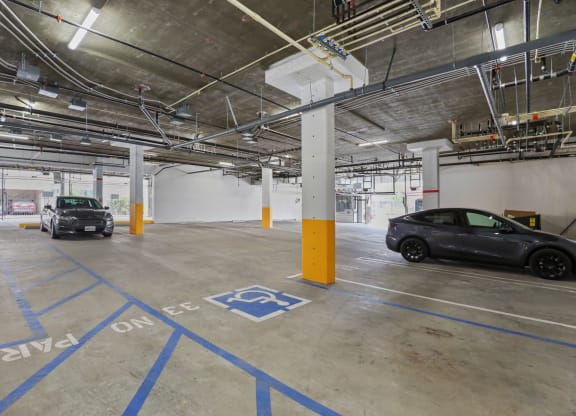 a parking garage with two cars in it at The Fairfax Flats Apartments, Los Angeles, California