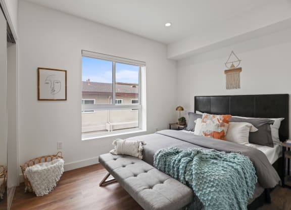 a bedroom with a large bed and a large window at The Fairfax Flats Apartments, Los Angeles, CA