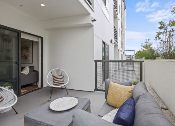 two chairs and a couch on a balcony in a 555 waverly unit at The Fairfax Flats Apartments, Los Angeles, CA