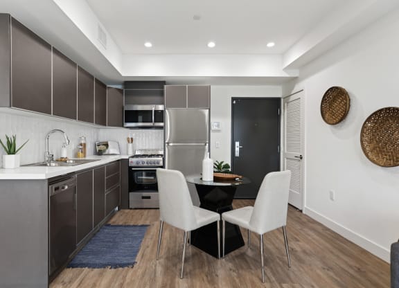 a kitchen with dark cabinetry and white countertops at The Fairfax Flats Apartments, Los Angeles, CA