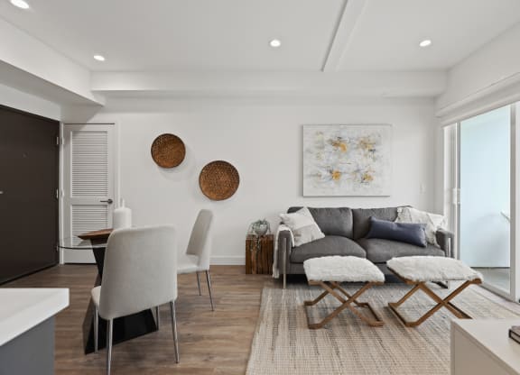 a living room with white walls and a gray couch at The Fairfax Flats Apartments, California
