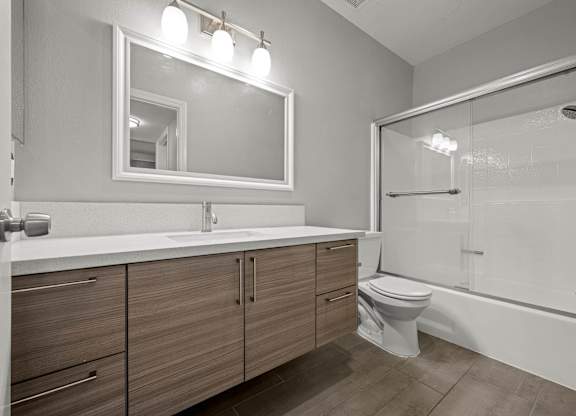 A modern bathroom with a white sink and a large mirror at Lafayette Apartments, Los Angeles