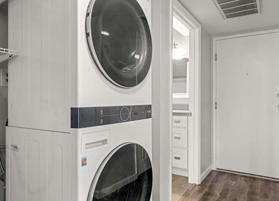 A laundry room with a washer and dryer stacked on top of each other at Lafayette Apartments, Los Angeles 90019