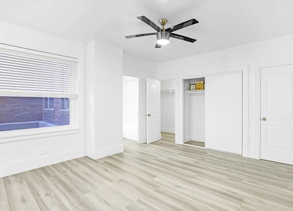 A room with a ceiling fan and wooden flooring.at Park Wilshire, Los Angeles