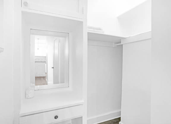 A white bathroom with a mirror and a sink.at Park Wilshire, Los Angeles, CA 90057