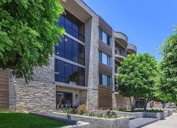 A modern building with a stone facade and large windows at Lafayette Apartments, Los Angeles