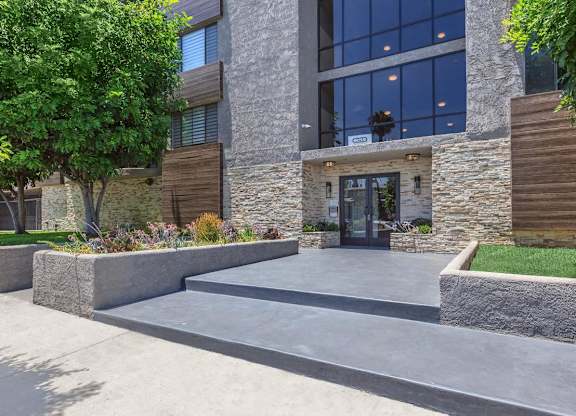 A modern building with a stone facade and a glass entrance at Lafayette Apartments, California