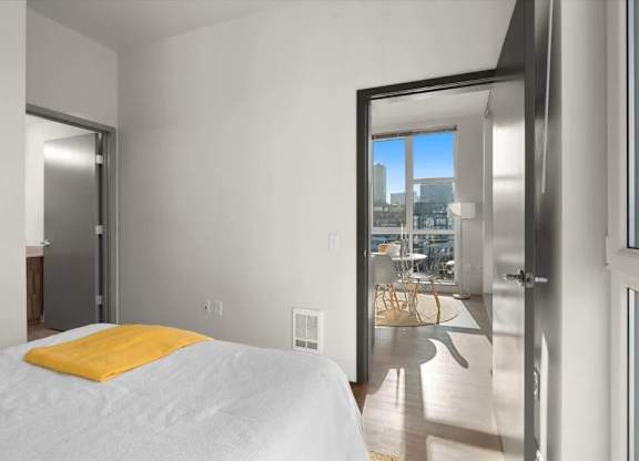 A bedroom with a large bed and a view of the city.