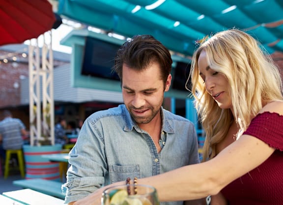 A man and a woman are sitting at a table with food and drinks.