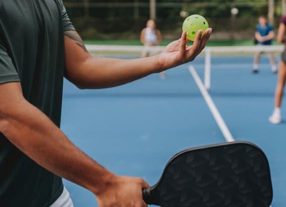 A person is holding a tennis racket and ball.