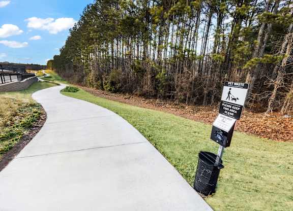 A white sign on a black pole indicates a pet walking area.