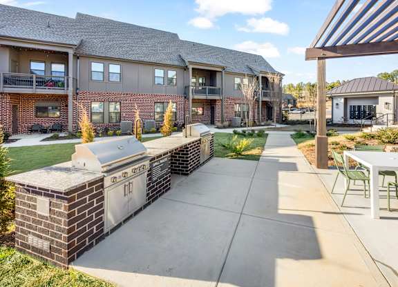 A sunny day at a residential complex with a walkway and greenery.