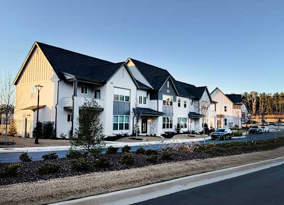 A row of houses with a road in front of them.
