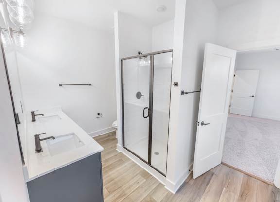 A bathroom with a sink, mirror, and shower.