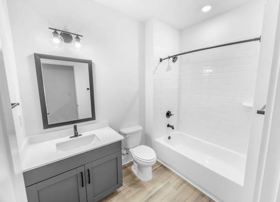 A white bathroom with a sink, toilet, and bathtub.
