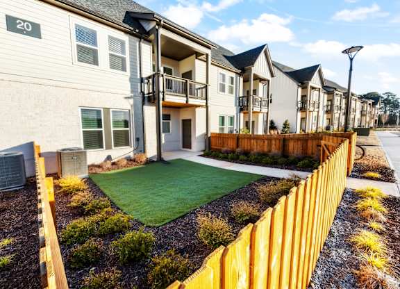 A row of houses with a yellow fence in front.