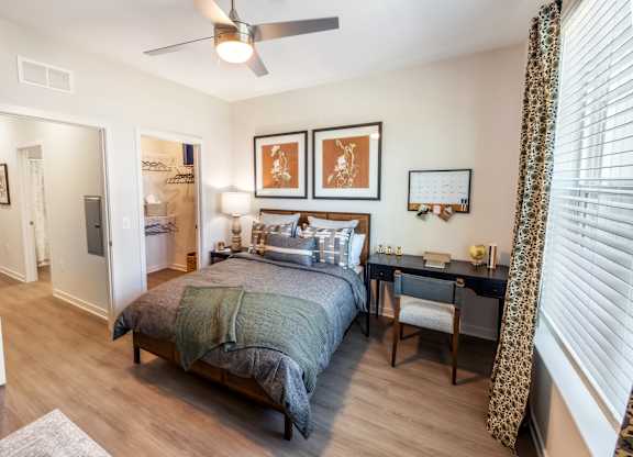 A bedroom with a bed, desk, and chair.