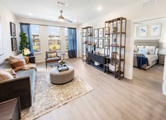 A living room with a large window, a couch, a coffee table, and a TV.