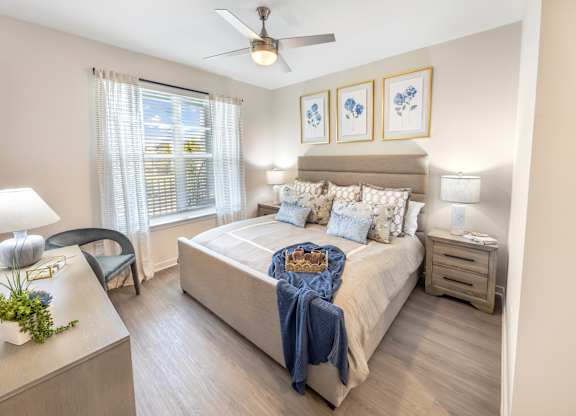 A bedroom with a bed, nightstand, and chair.