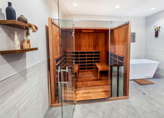 A modern bathroom with a wooden shower stall and white walls.
