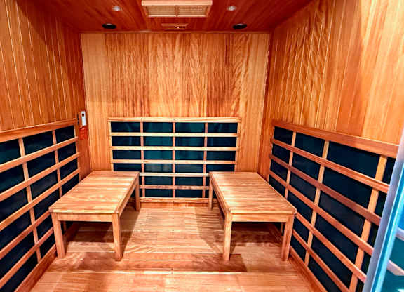 A wooden bench is in the middle of a room with wooden walls.