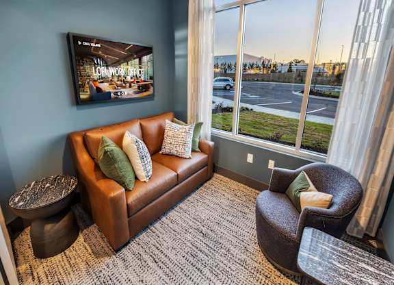 A living room with a brown couch and a television displaying a "Low Work Off" advertisement.