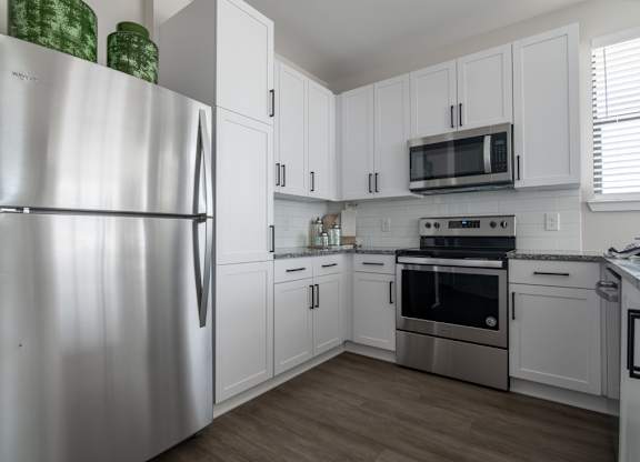 a kitchen with stainless steel appliances and white cabinets