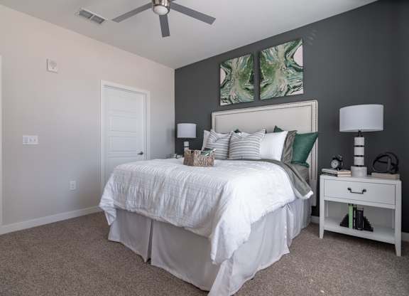 a bedroom with a white bed and a ceiling fan