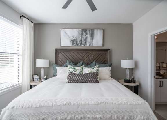 a bedroom with a large bed and a ceiling fan