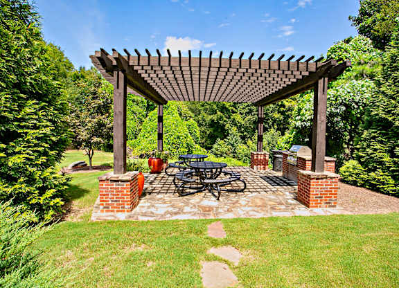 A wooden pergola with a bicycle parked under it.