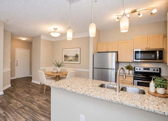 A kitchen with a stainless steel refrigerator, microwave, and oven.