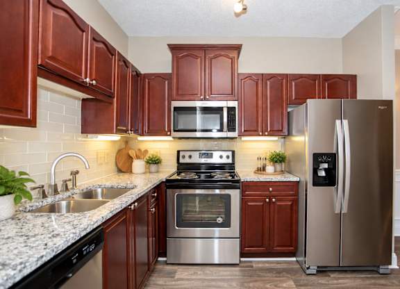 A kitchen with brown cabinets and stainless steel appliances.
