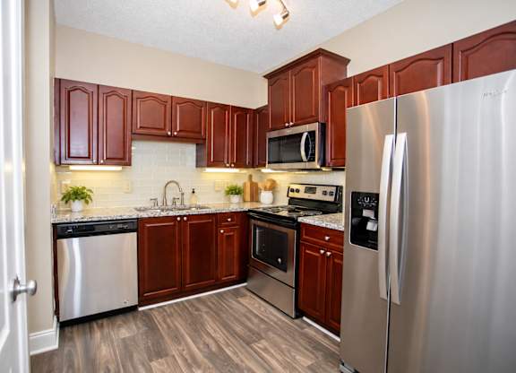 A kitchen with brown cabinets and a stainless steel refrigerator.