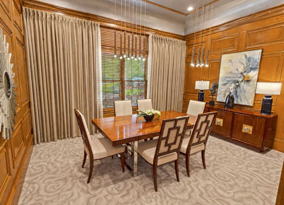 A dining room with a wooden table and chairs.